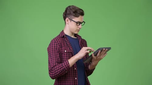 Young Adult Using Tablet on Green Background