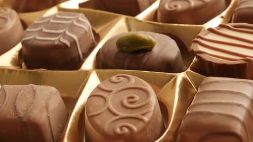 Gift box of chocolates many different candies slow tilt 4K 2160p 30fps UltraHD footage - Tilting ove