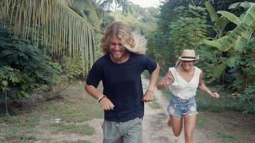 Couple Runs Holding Hands Through Tropical Paradise