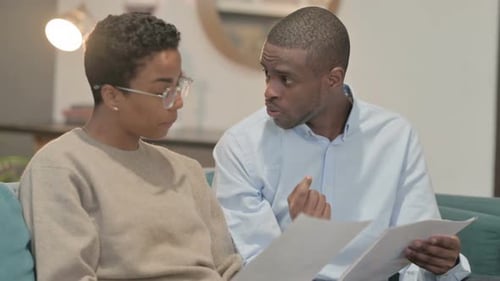 Couple Reviewing Documents Together in Home Setting