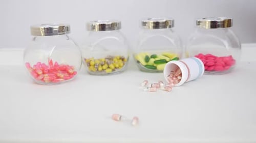 Colorful Pills in Glass Jars with Spilled Medicine