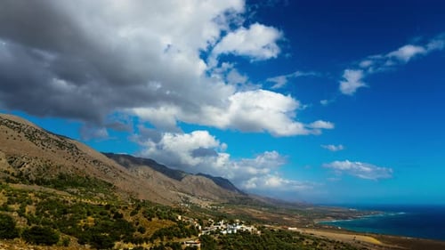 Zeitraffer: Mittelmeer. Weiße, flauschige Wolken bewegen sich über Hügel.