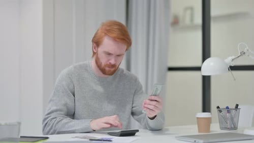 Rothaariger Mann benutzt Taschenrechner beim Dollarzählen