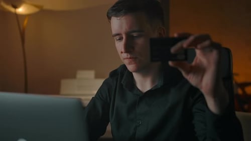 Man Uses Credit Card with Laptop at Home