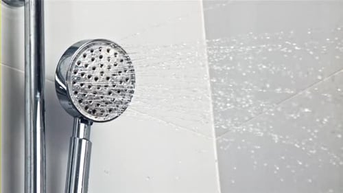 Shower Head Sprays Water in Bathroom Close-up