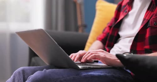 Young American Man Relaxing and Using Laptop Computer