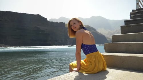 Woman Smiles by Sea on Bright Sunny Day