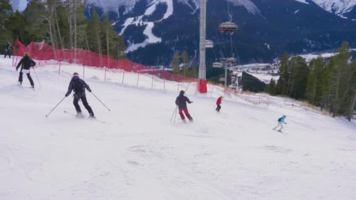 Skier Skiing and People on Snowboards Ride Down the Slope on Ski Resort in Mountains Winter.