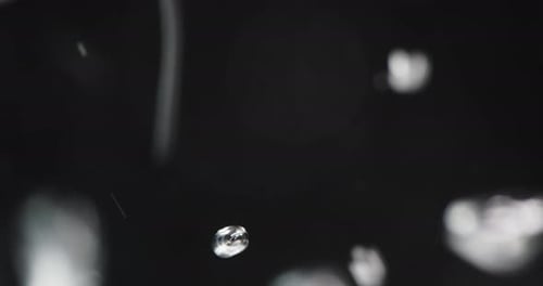 Wasser wird in Flüssigkeit gegossen und erzeugt aufsteigende Blasen