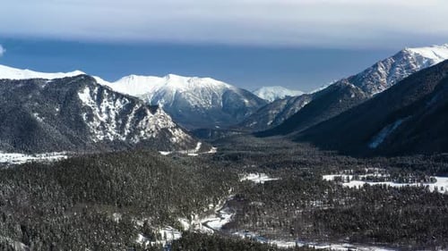 Air Flight Through Mountain Clouds Over Beautiful Snowcapped Peaks of Mountains and Glaciers