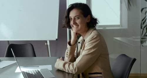 Smiling Woman at Desk in Modern Workplace