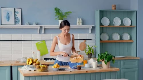 Young Woman Making Fruit Salad in Kitchen