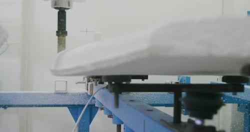 Surfboard being shaped by a machine in a workshop