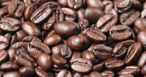 Pile of aromatic roasted coffee beans close up