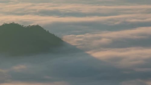 Mountain Peak Surrounded by Gentle Fog at Sunrise