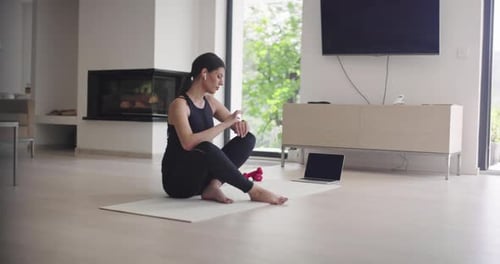 Woman Working Out at Home with Laptop and Watch
