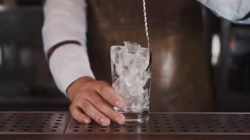 Bartender Stirring Ice in Clear Glass