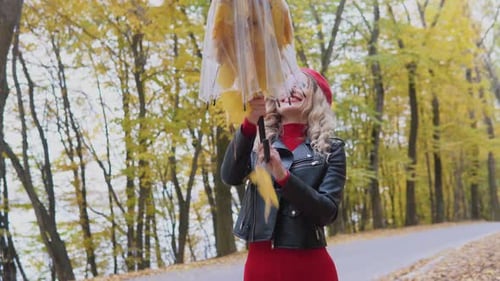 Woman with Leaves in Umbrella in Autumn
