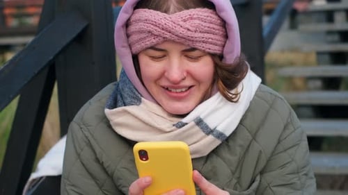 Woman Blogger in Warm Clothes Makes a Post in a Social Media Outdoors Traveller on the Winter Beach
