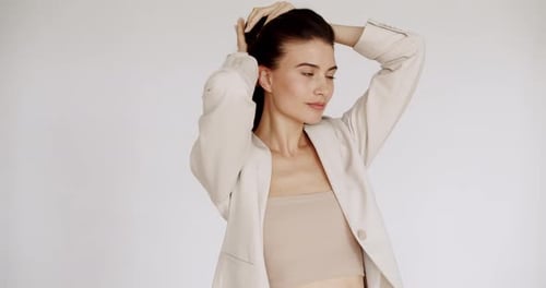 Woman Tying Hair Into Ponytail Smiling