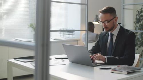 Caucasian Businessman Working on Laptop at Office Desk