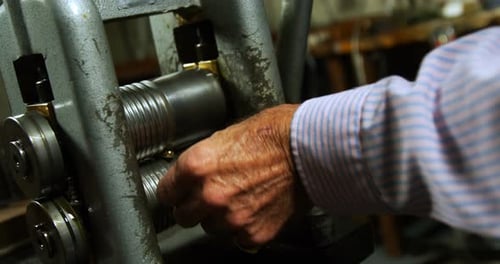 Goldsmith working on machine in workshop