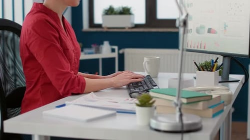 Woman Typing at Desk in Modern Office