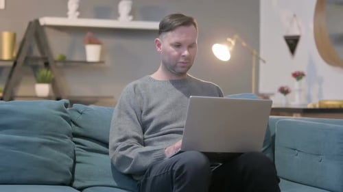 Man Working on Laptop Computer from Home