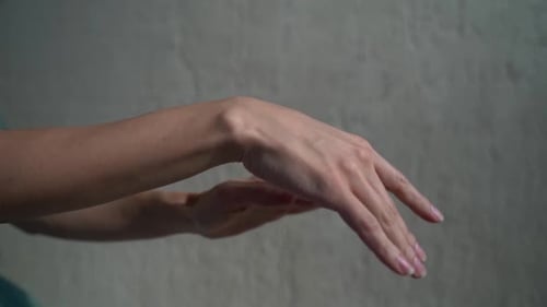 Hands Performing Intricate Gestures Against Grey Background