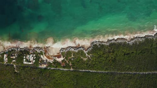 Vista superior em câmera lenta de uma praia tropical vazia em Tulum, México, com uma extensa vegetação e floresta