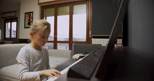 Girl Plays Piano Indoors During Daytime