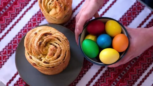 Junge Frau legt frisch gebackenen Osterkuchen-Cruffin auf den Küchentisch
