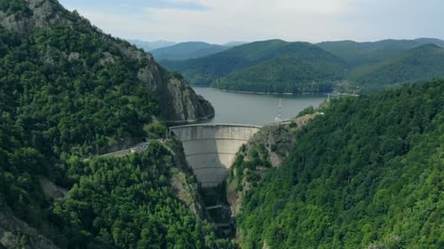 Aerial View of a Hydroelectric Dam in the Mountains Covered with Forest
