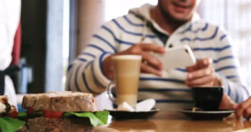 Friends at Cafe with Coffee and Sandwiches