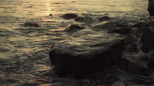 Waves Lapping Over Rocks at Sunset