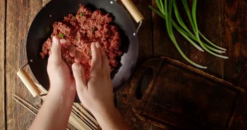 Hands Preparing Meatballs with Skewers Overhead Shot