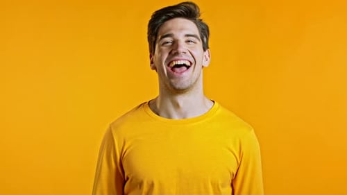 Dark Haired Man Smiling on a Yellow Background
