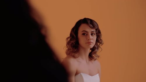 Young Woman Posing in Front of Orange Background