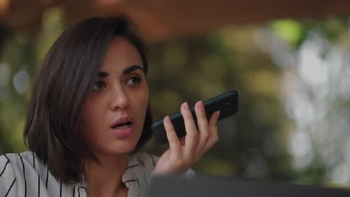 Confident Business Woman Recording Audio Message on Smartphone at Street