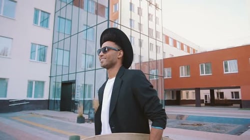 Stylish Young Adult Walking With Skateboard