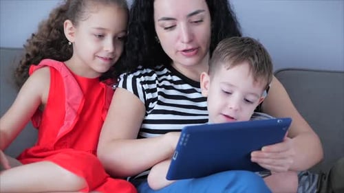 Mother and Children Enjoying a Tablet at Home
