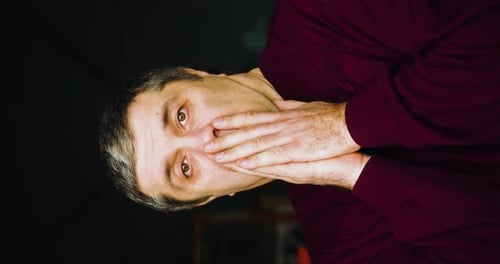 Adult Man Expressing Surprise with Hands to Mouth