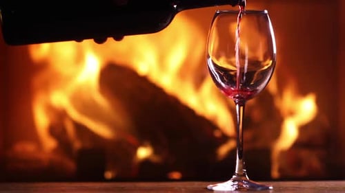 A Man's Hand Pours Red Wine Into a Glass