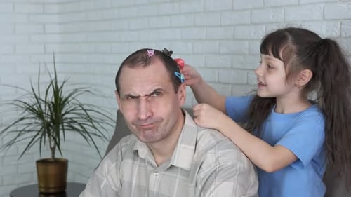 Girl Putting Hair Clips on Dad's Head