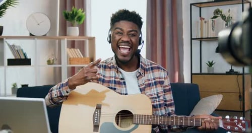 Hombre afroamericano con auriculares que mira a la cámara con una cara feliz