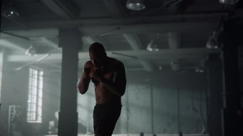 Man Practicing Kickboxing in Gym