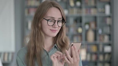 Portrait of Young Woman Using Smartphone in Office