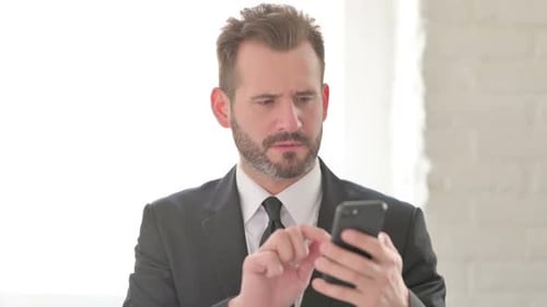 Adult Man Frustrated Using Smartphone