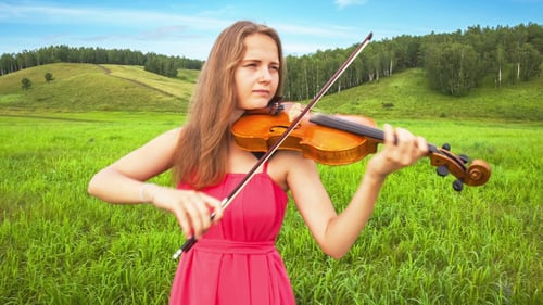 Woman Plays Violin in a Beautiful Field
