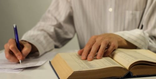 Mann arbeitet mit Papieren am Tisch - 02